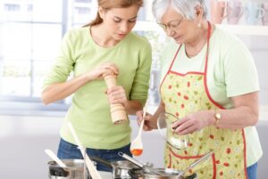 senior mother and daughter preparing a meal together